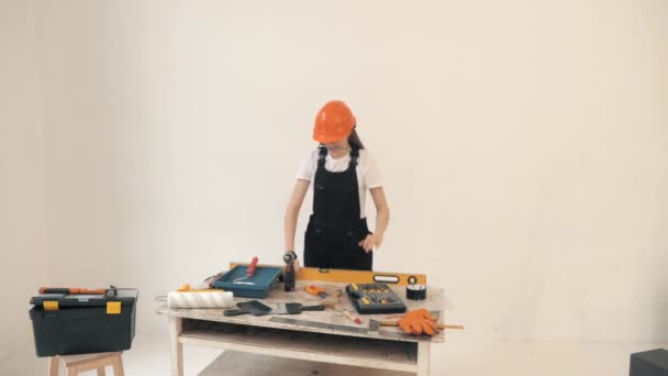 Frau in Bauarbeiteruniform überprüft Werkzeug vor der Arbeit — Stockvideo