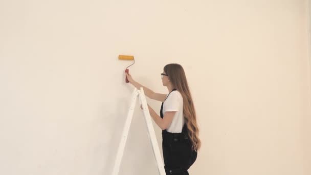 Jong meisje bouwer op bouwplaats met verfroller — Stockvideo