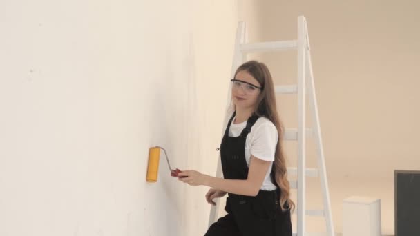 Jong meisje bouwer op bouwplaats met verfroller — Stockvideo