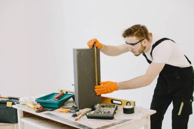 Beyaz arka planda üniformalı bir tesisatçı.