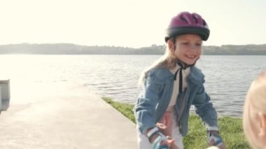 Kasklı kız yazın annemle göl kenarında paten kaymaya gider.