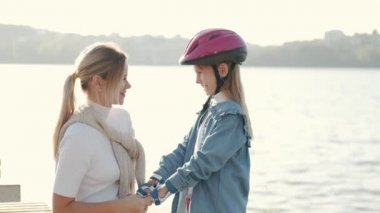 Anne ve kızı spor malzemeleriyle dışarıda sarılıyorlar.