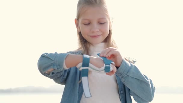 Niña poniendo equipo de protección antes de deporte actividad al aire libre — Vídeos de Stock