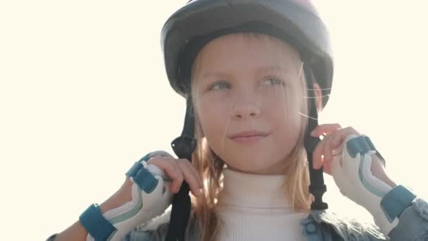 Niña poniendo equipo de protección antes de deporte actividad al aire libre — Vídeos de Stock