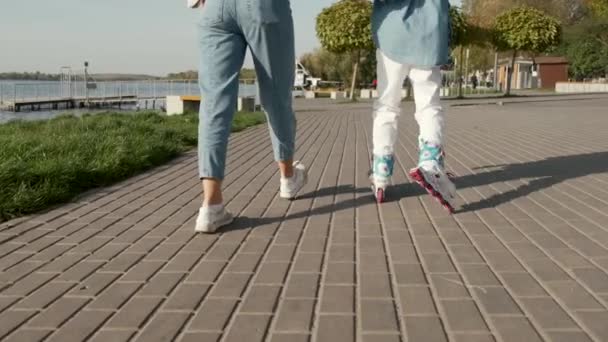 Mädchen mit Helm gehen im Sommer mit Mama am See Rollschuhlaufen — Stockvideo