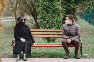 Maskeli insanlar sokakta duruyor.