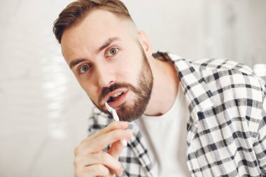 Dişlerini fırçalayan genç bir adamın portre görüntüsü