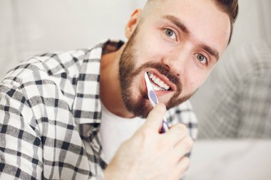 Dişlerini fırçalayan genç bir adamın portre görüntüsü