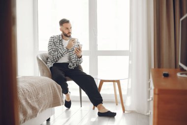 Çekici zeki adam oturma odasında oturuyor.