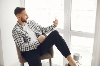 Çekici zeki adam oturma odasında oturuyor.