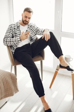 Çekici zeki adam oturma odasında oturuyor.