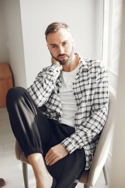 Çekici zeki adam oturma odasında oturuyor.