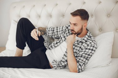 Çekici, zeki bir adam, kötü bir odada yatıyor.