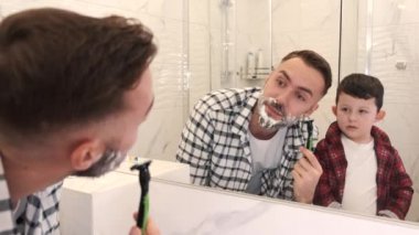 Hoş bir adam oğluna tıraş olmayı öğretiyor.