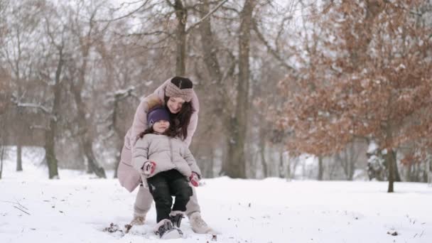 Feliz madre europea y su pequeña hija divirtiéndose en el bosque de invierno — Vídeos de Stock