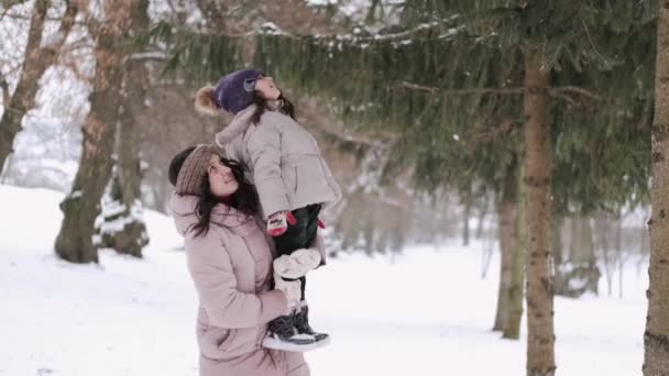 Feliz madre europea y su pequeña hija divirtiéndose en el bosque de invierno — Vídeos de Stock