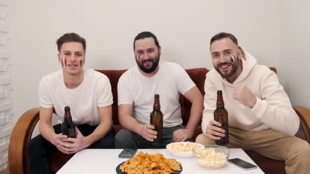 Grupa fanów szczęśliwych przyjaciół ogląda mecz w telewizji z piwem — Wideo stockowe