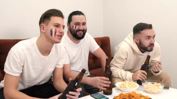 Groep gelukkige vrienden fans kijken naar een wedstrijd op tv met bier — Stockvideo