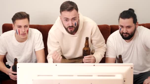 Groep gelukkige vrienden fans kijken naar een wedstrijd op tv met bier — Stockvideo