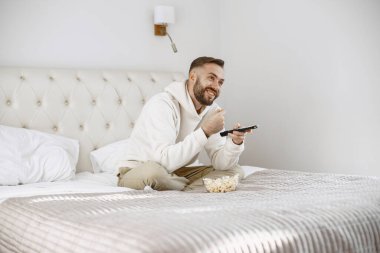 Kanepede televizyon izleyen bekar bir adam.