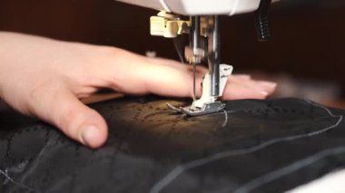 Dikiş makinesiyle çalışan yaratıcı kadın terzi.