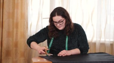 Masada kumaşla çalışan terzi.