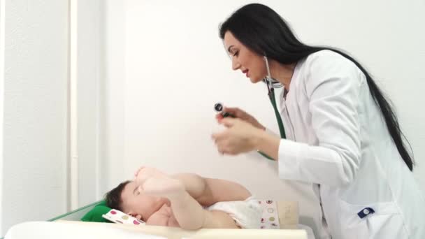 Medico femminile pediatra esaminando il bambino in clinica — Video Stock