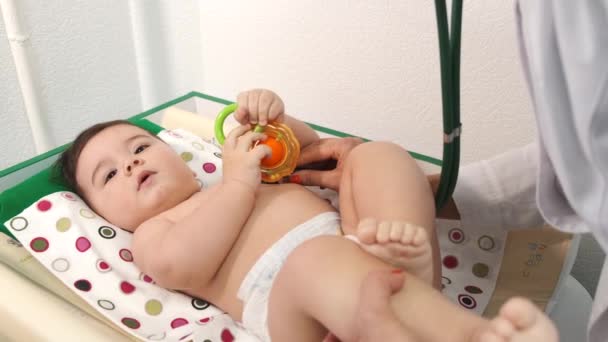 Pediatra doctora examinando bebé en clínica — Vídeos de Stock