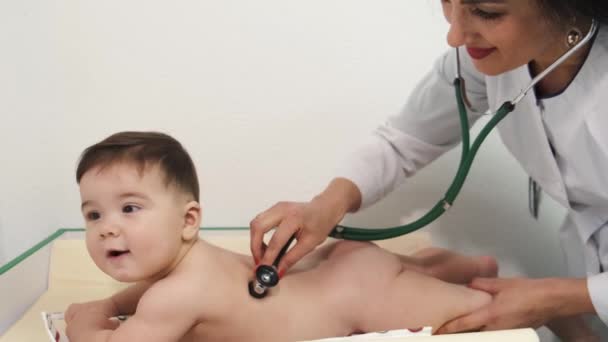 Női orvos gyermekorvos vizsgálja a baba a klinikán — Stock videók