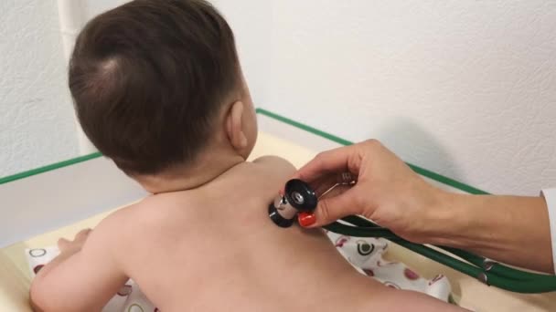 Pediatra doctora examinando bebé en clínica — Vídeos de Stock
