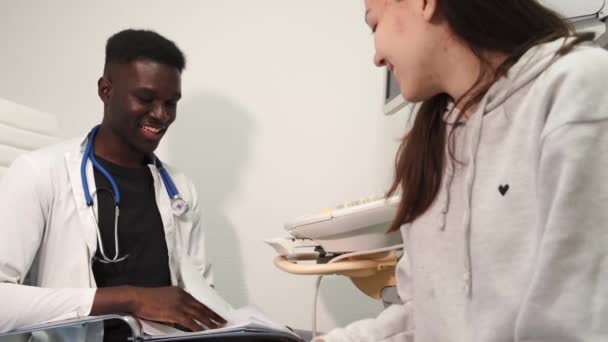 Mann spricht Patientin nach Ultraschalluntersuchung an — Stockvideo
