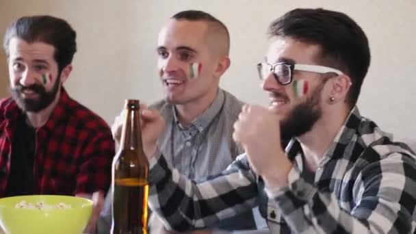 Retrato de tres amigos animando al equipo italiano en casa — Vídeos de Stock