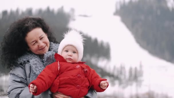 Ευτυχισμένη γιαγιά που κρατάει το μωρό της στα βουνά του χειμώνα. — Αρχείο Βίντεο
