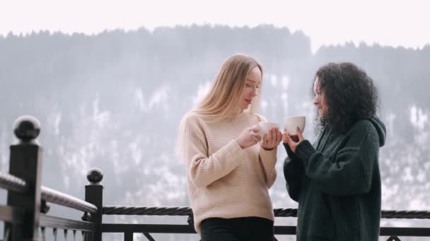 Madre e bella figlia a bere caffè su un balcone con montagne paesaggio — Video Stock