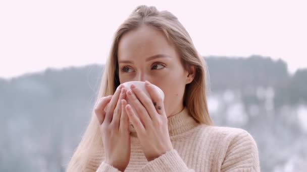 Menina loira europeia bonita beber café e relaxar na varanda do hotel de montanha — Vídeo de Stock