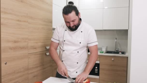 Üniformalı şef modern mutfakta çorba için patlıcan kesiyor. — Stok video