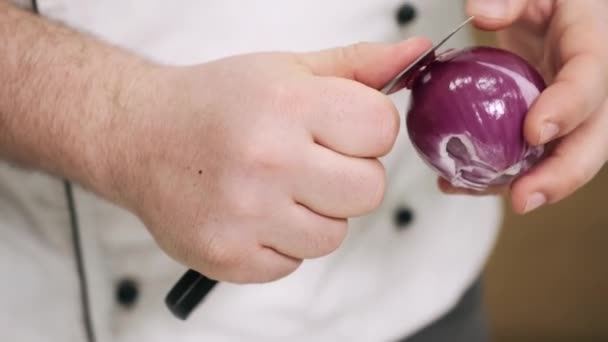 Szef kuchni kroi purpurową cebulę na czarnym biurku — Wideo stockowe