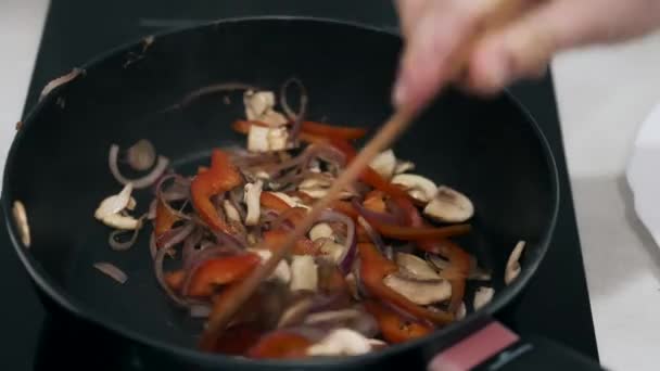 Chef fritando legumes na frigideira na cozinha mosern — Vídeo de Stock