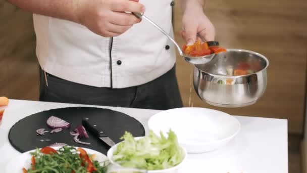 Chef macho sirviendo sopa caliente de verduras en un tazón — Vídeos de Stock