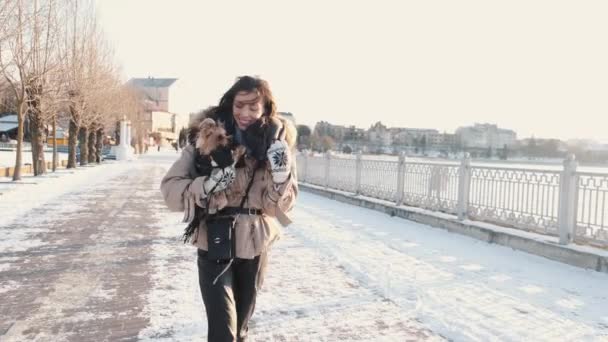 Ευτυχισμένο νεαρό κορίτσι ιδιοκτήτης με yorkshire τεριέ σκυλί με τα πόδια στο πάρκο το χειμώνα — Αρχείο Βίντεο