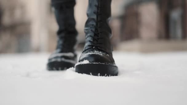 雪の地面に行く革のブーツの女性の足の閉じるアップ — ストック動画