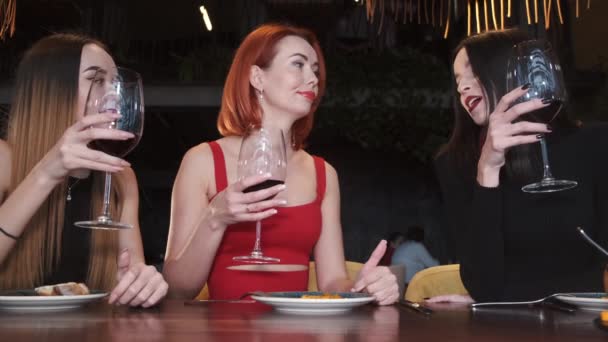 Jovens felizes bebendo vinho e conversando no restaurante — Vídeo de Stock
