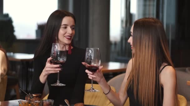 Jovens felizes bebendo vinho e conversando no restaurante — Vídeo de Stock