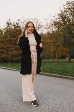 Sonbahar parkında zarif bir kadın.