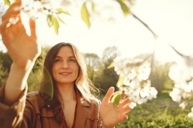 Şık bir kadın bahar parkında vakit geçiriyor.