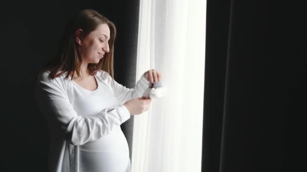 Schwangere steht zu Hause am Fenster — Stockvideo