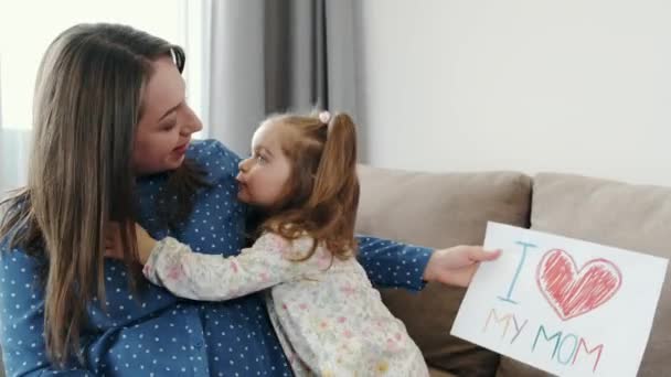 Маленька дівчинка з вагітною матір'ю малює фото вдома — стокове відео