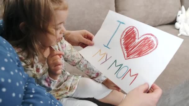 Little girl with pregnant mother drawing a picture at home — Stock Video