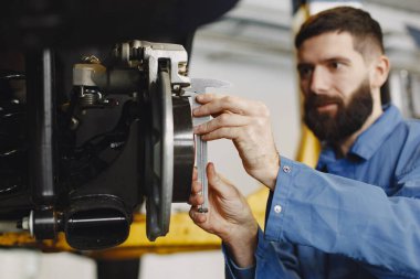 Asansördeki garajda adam tekerleği değiştiriyor.