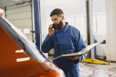 Araba tamircisi soruları belgelerle telefonla çözer.